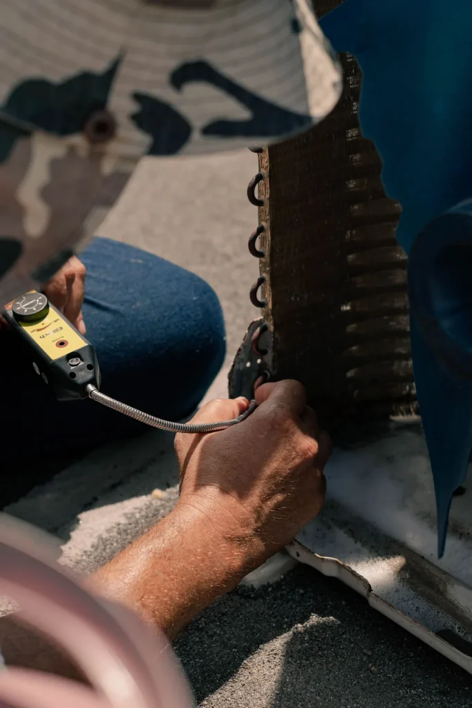 Close-up of an AC condenser coil being checked during a service visit
