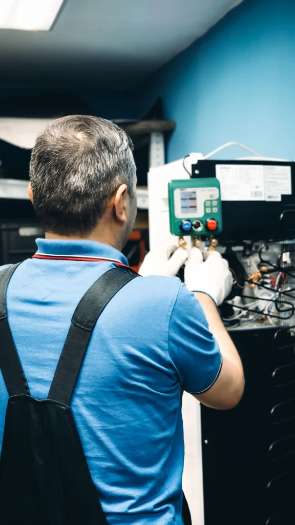 Air conditioning engineer checking system pressure with a manifold gauge set